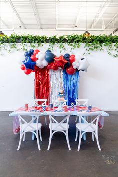 the table is set up with red, white and blue balloons