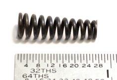 a close up of a coil next to a ruler