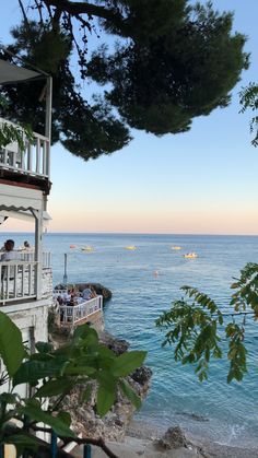 people are sitting on the balcony overlooking the ocean