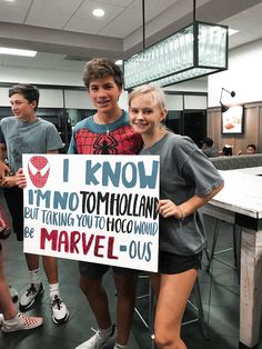 two young people holding up a sign that says i know immo to hollywood but taking you to hoo around the marvel - o's