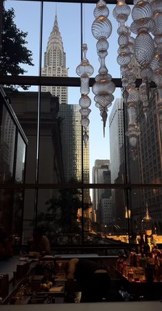 the view from inside a restaurant looking out at skyscrapers