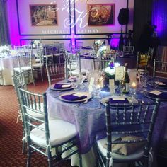 a table set up with purple and white linens