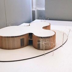 an architectural model of a building made out of wood and white plexed paper