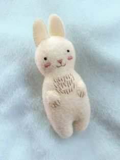 a white stuffed animal sitting on top of a blue blanket with the words free pattern written below it