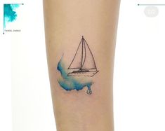 a small sailboat tattoo on the left calf leg, with blue watercolors