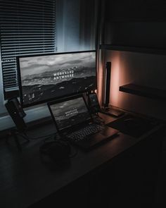 a desktop computer sitting on top of a wooden desk next to a laptop and headphones