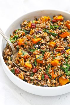 a white bowl filled with wild rice and vegetables