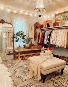 a room with clothes hanging on the wall and a bench in front of it that has a chandelier