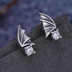 Sparkle and shine with a touch of glamor! These earrings are made from superior quality 925 Sterling Silver that promises durability. The ear studs are carved in the shape of a Vintage Wing and studded with white CZ stones. The studs can be easily worn or taken off as it has a push back lock adjustment. Wear it with ethnic or western outfits and feel stylish and beautiful. Earring Type: Stud EarringsFine or Fashion: FashionStyle: VintageMetals Type: SilverGender: WomenMaterial: Cubic ZirconiaBac Hypoallergenic Silver Cubic Zirconia Earrings, Elegant Wing-shaped Silver Jewelry, Elegant Silver Wing-shaped Jewelry, Elegant Silver Internally Threaded Earrings, Silver Cubic Zirconia Earrings For Pierced Ears, Formal Sterling Silver Jewelry With Internally Threaded, Silver Earrings With Prong Setting As Gift, Sterling Silver Earrings In Diamond White, Silver Cubic Zirconia Round Plug Earrings