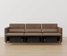 a couch sitting on top of a hard wood floor next to a white wall and wooden floors