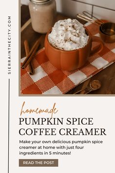 a pumpkin spice coffee creamer is on a checkered tablecloth with cinnamon sticks