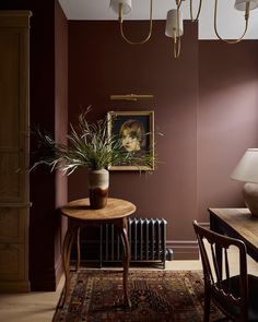 a dining room with a table, chair and painting hanging on the wall next to a radiator