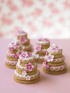 there are many small decorated cookies on the pink tablecloth, and one is for sale