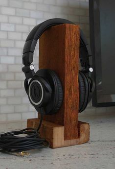 headphones are sitting on top of a wooden stand