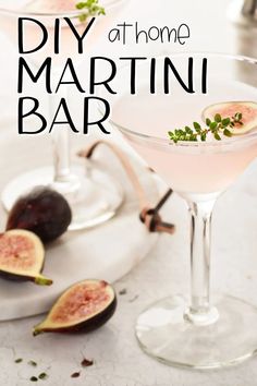 two martini glasses filled with pink wine and topped with fresh figs on a white table