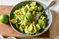 a bowl filled with avocado and sliced limes