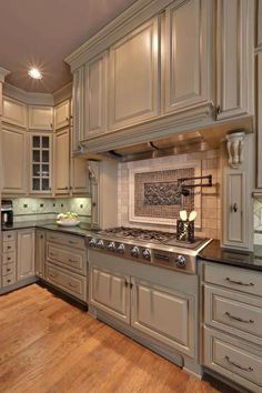 a kitchen with an oven, stove and counter tops in beige color wood flooring