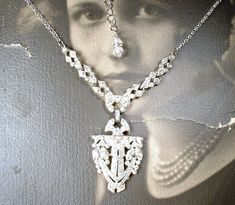 "Offering a gorgeous antique 1920's - 1930's era Art Deco French paste pave rhinestone Flapper pendant lavaliere necklace perfect for the Bride! I absolutely adore this necklace! The SO Art Deco ornate geometric shaped shiny silver pot metal pendant is lavishly encrusted with marquise and baguette cut as well as small round cut closely pave set brilliantly clear sparkly crystal rhinestones. The pendant hangs from ornate links that compliment the pendant so well and are adorned with more clear sp Art Deco Crystal Jewelry For Vintage Events, Art Deco Crystal Jewelry For Vintage, Antique Bridal Necklace With 17 Jewels For Wedding, Art Deco Crystal Necklace For Wedding, Art Deco Rhinestone Jewelry For Wedding, Art Deco Wedding Jewelry With Rhinestones, Flapper 1920s, 1930s Wedding, Flapper Necklace