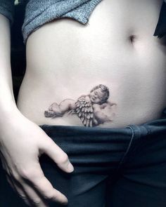 a woman's stomach with an angel tattoo on it