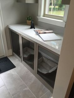 a white counter top sitting under a window next to a black mat on the floor