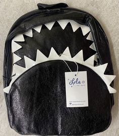 Lola and the Boys SHARK CHOMP MINI BACKPACK. Dimensions: 11.5 x 9.5 inches Back To School Satchel Backpack As Gift, Back-to-school Satchel Backpack As Gift, Casual Black Backpack For Gift, Trendy Backpack For Back To School Gift, Trendy Backpack For End Of School Year Gift, Trendy Standard Backpack Ideal For Gifts, Mini Backpack, The Boys, Backpacks