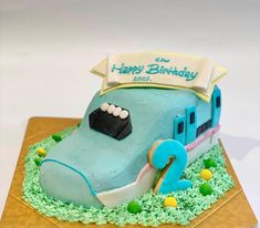 a blue birthday cake with an elephant on the front and trailer on the back that says happy birthday