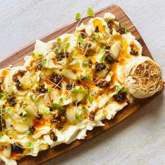 a wooden cutting board topped with food on top of a table