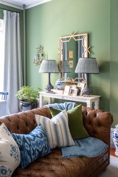 a living room filled with lots of furniture and pillows on top of a brown couch