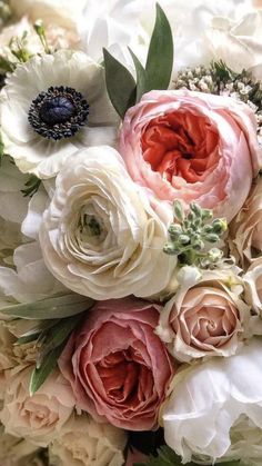 a bouquet of white and pink flowers with green leaves