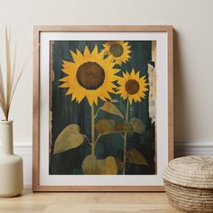 a painting of sunflowers in a frame next to a basket and vase on the floor