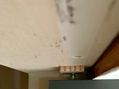 the corner of a room with moldy paint on the walls and ceiling above it