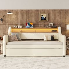 a living room with a white couch and wooden walls