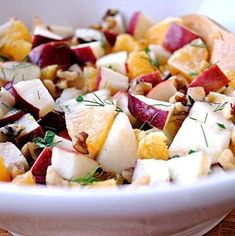 a white bowl filled with fruit and nuts