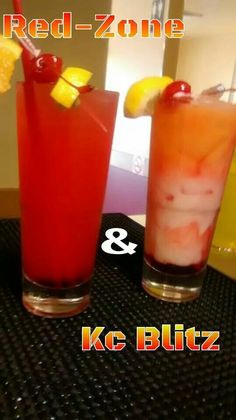 two glasses filled with drinks sitting on top of a black table next to each other