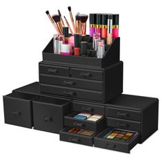 an assortment of black drawers with makeup brushes and other items in them on a white background