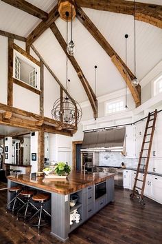 a large kitchen with wooden beams and white walls