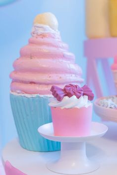 cupcakes with pink and blue frosting sitting on top of a cake stand