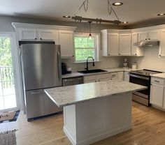 a kitchen with white cabinets and stainless steel appliances