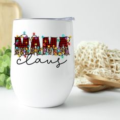 a white coffee cup with the word mama claus on it next to some sprinkles