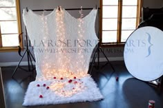 a white backdrop with lights on it in front of a camera set up for a photo shoot