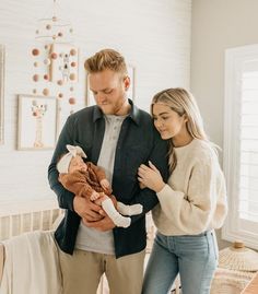 a man and woman holding a baby in their arms