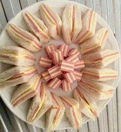 a white plate topped with cut up sandwiches on top of a wooden table next to a radiator