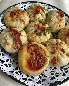 some dumplings are on a black and white plate