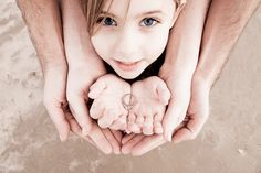 two people holding their hands together on the beach