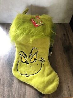 a yellow christmas stocking with an angry grin face drawn on it's side