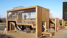 children playing in an outdoor play structure made out of wood