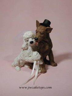 a dog and a sheep figurine sitting on top of each other in front of a pink background