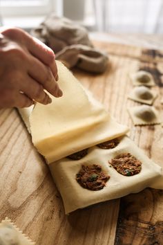 a person is making homemade pastries on a wooden table with dough and other ingredients