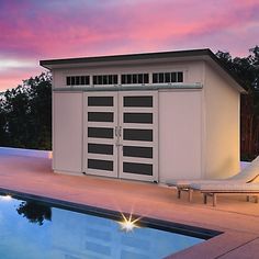 a swimming pool next to a building with a sun lounger in front of it