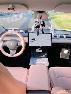 the interior of a car is decorated with pink and white decorations, including a steering wheel